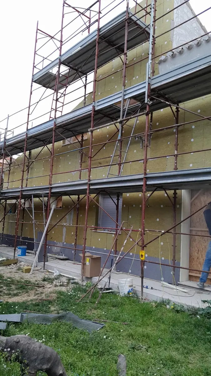 Posa del cappotto termico su un edificio con ponteggio