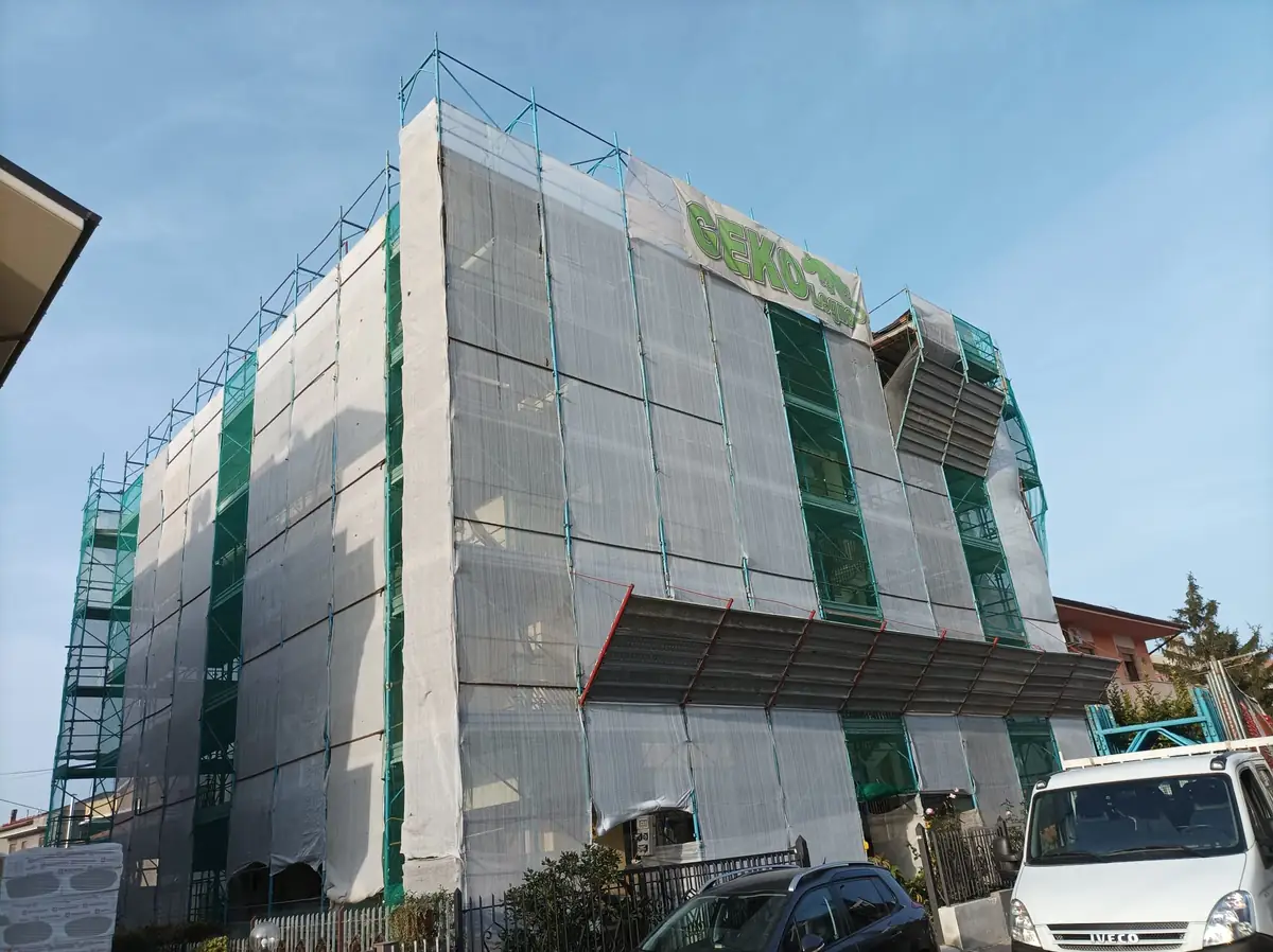 Edificio con ponteggio e teli di protezione durante il rifacimento della facciata